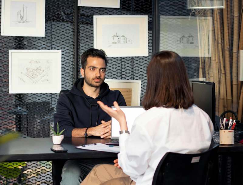 Two colleagues in conversation at a desk